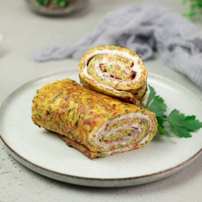 Diese Gemüserolle mit Schinken und Kräuterquark ist perfekt zum Mitnehmen. Man kann sie optimal kalt essen. Der Teig besteht aus Ei, Zucchini, Frischkäse und Karotte.